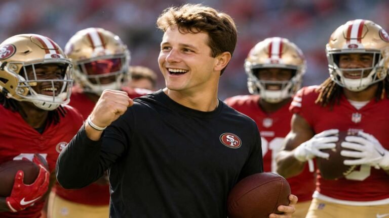San Francisco 49ers quarterback Brock Purdy drops back and fires a pass to wide receiver Mike Evans during 2026 OTA work at Levi’s Stadium, with Christian Kirk and De’Zhaun Stribling visible in the background.
