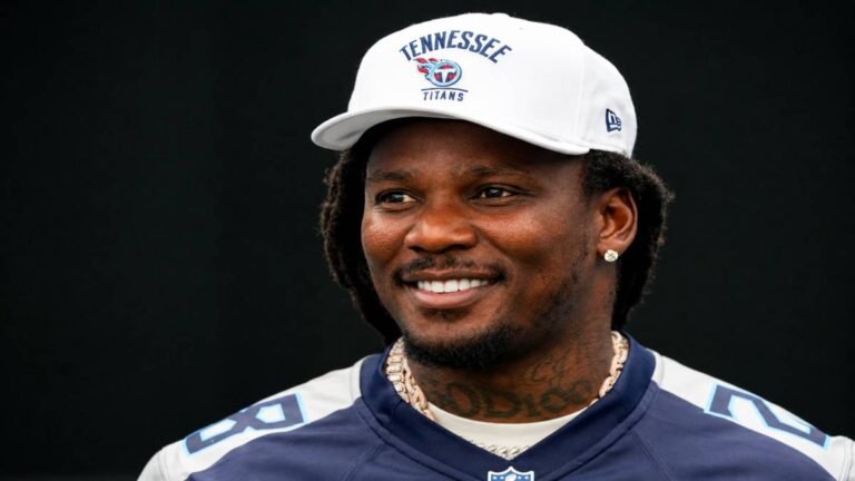Former Tennessee Titans running back Chris Johnson in uniform on the sideline, looking focused during his playing days.