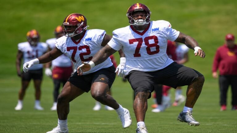 Washington Commanders offensive tackles Laremy Tunsil and Josh Conerly Jr. share an intense training moment on a sunlit Alabama football field, with Tunsil offering technique guidance during their dedicated offseason routine.