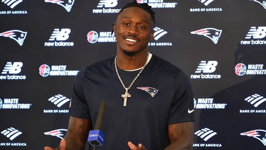 A.J. Brown in New England Patriots jersey number 11 standing confidently on the field at Gillette Stadium at sunset, dramatic golden hour lighting, professional NFL sports photography for article header.