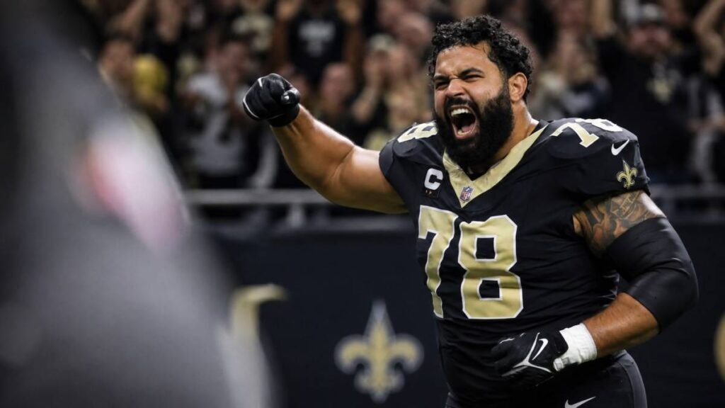 New Orleans Saints Pro Bowl center Erik McCoy #78 in uniform during 2026 OTAs, intense focused expression with offensive line teammates training in the background at the Ochsner Sports Performance Center.