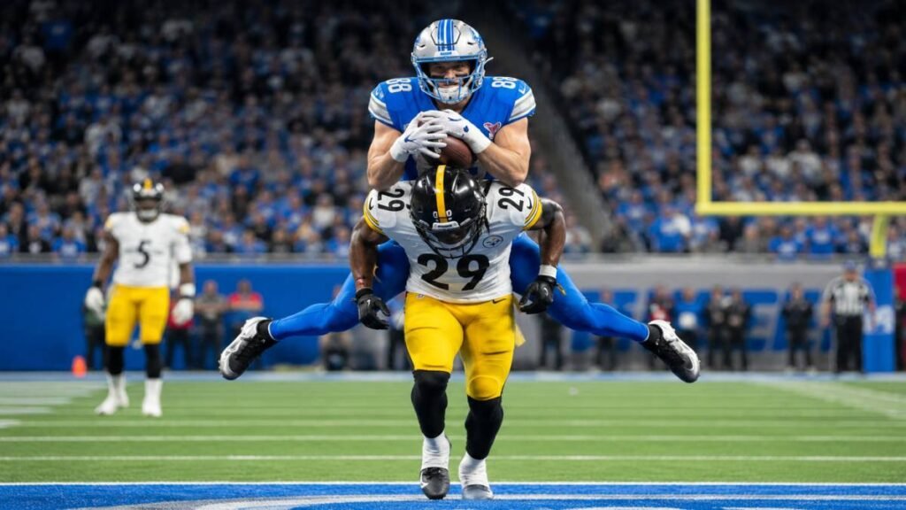 Detroit Lions wide receiver Isaac TeSlaa reaching for a one-handed catch during sunny 2026 summer practice at Allen Park.