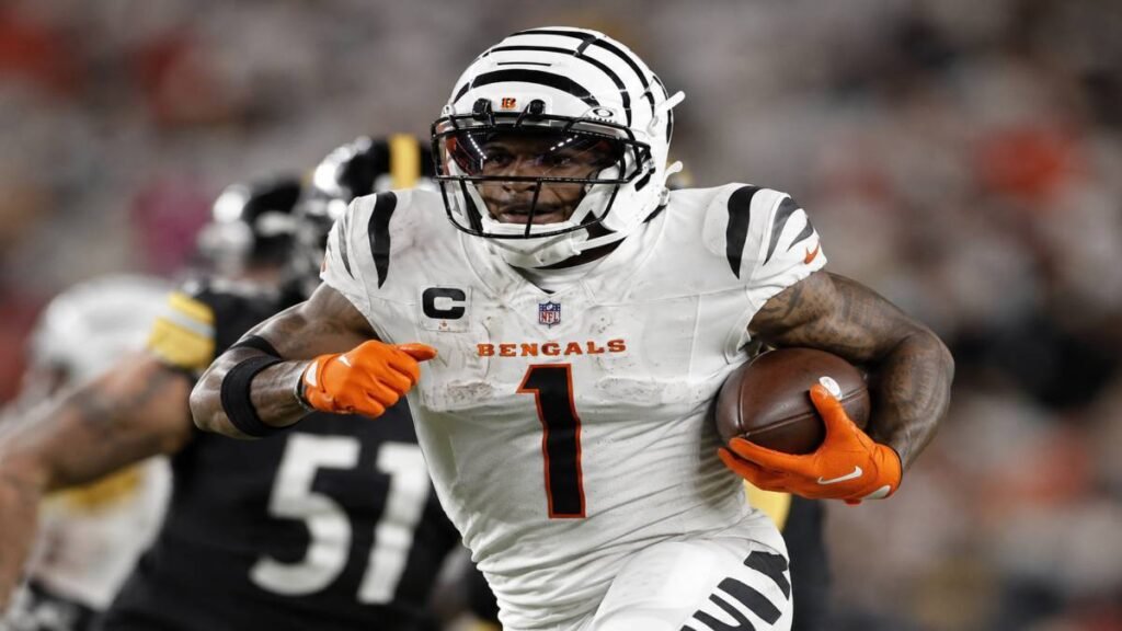 Ja'Marr Chase in full Bengals uniform securing a catch with athletic focus during an NFL game.