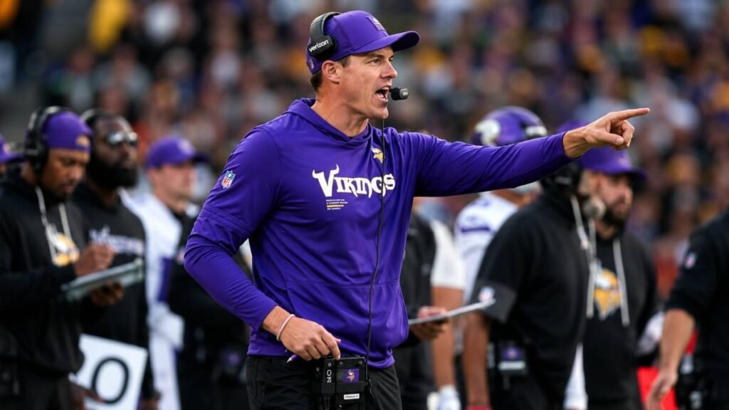 Minnesota Vikings head coach Kevin O’Connell holding a play sheet and speaking to quarterbacks during practice at training camp.